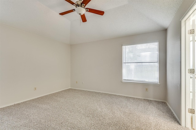 carpeted spare room with a textured ceiling, ceiling fan, and vaulted ceiling