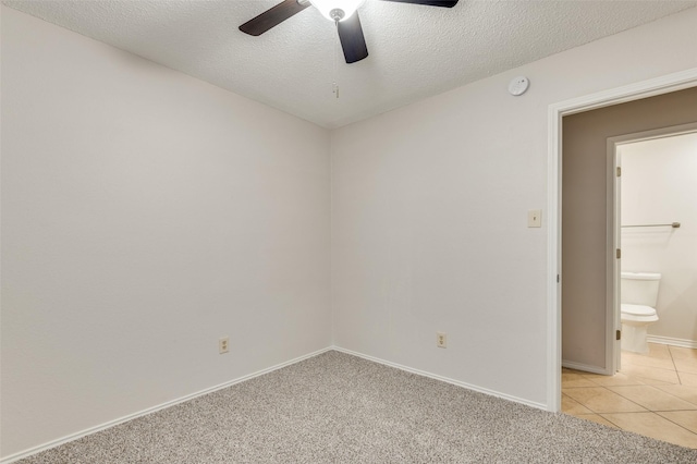 carpeted spare room featuring a textured ceiling and ceiling fan