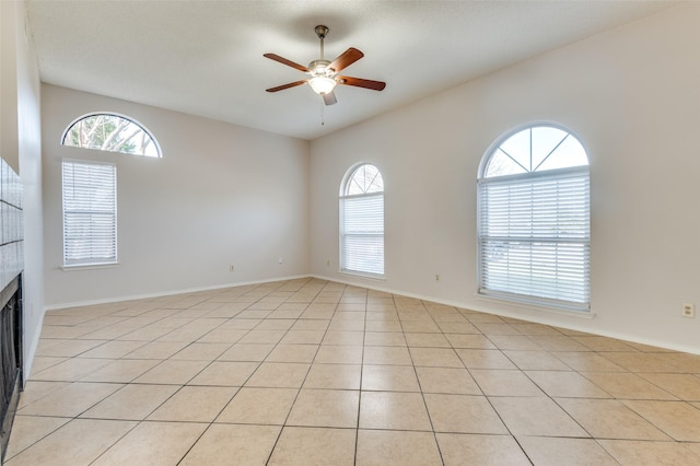 unfurnished room with light tile patterned flooring, ceiling fan, and plenty of natural light