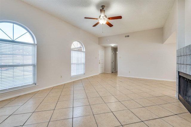 unfurnished living room with ceiling fan, light tile patterned floors, and a wealth of natural light