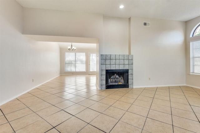 unfurnished living room featuring a notable chandelier, a fireplace, and light tile patterned floors