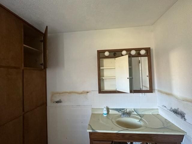 bathroom featuring a textured ceiling and vanity