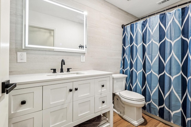 bathroom featuring a shower with curtain, vanity, wood-type flooring, and toilet