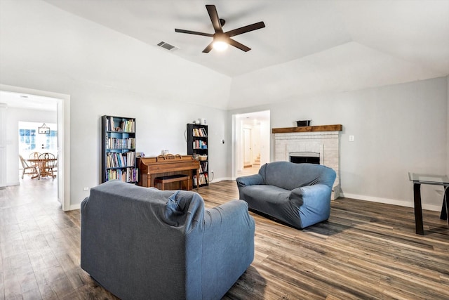 living room with a raised ceiling, dark hardwood / wood-style flooring, ceiling fan, and a fireplace