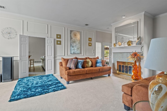 living room with crown molding, carpet floors, and a tile fireplace