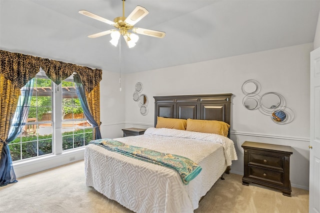 carpeted bedroom with ceiling fan and vaulted ceiling