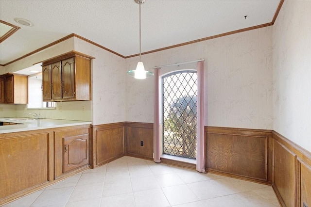 kitchen with crown molding, decorative light fixtures, sink, and a textured ceiling