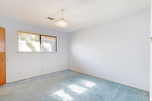 carpeted empty room with a textured ceiling