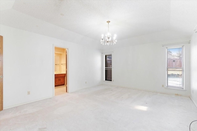 unfurnished room with light colored carpet, lofted ceiling, a textured ceiling, and a notable chandelier