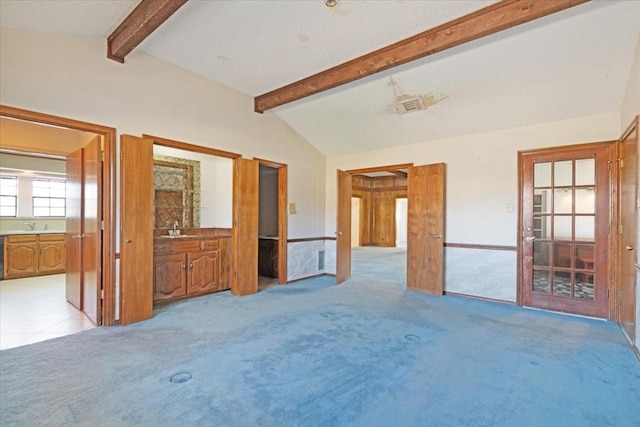 carpeted spare room featuring sink and lofted ceiling with beams