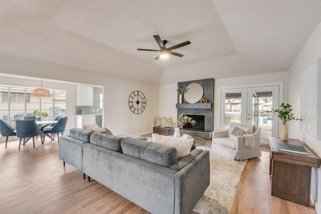 living room with hardwood / wood-style floors, french doors, ceiling fan, a textured ceiling, and a tray ceiling