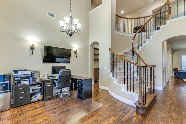 office area with a high ceiling, a notable chandelier, and dark hardwood / wood-style flooring