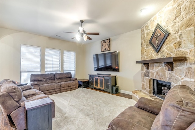 living room with a fireplace and ceiling fan