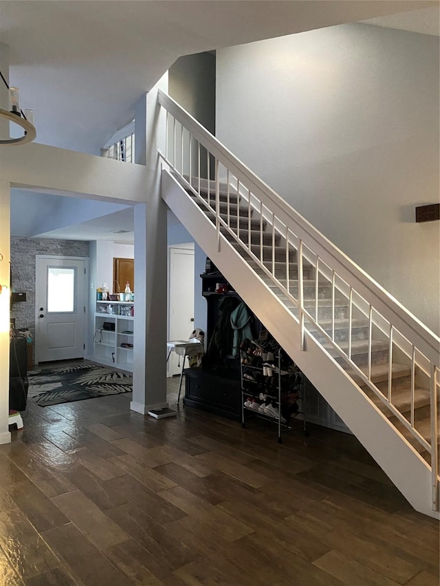 staircase featuring a towering ceiling and hardwood / wood-style floors