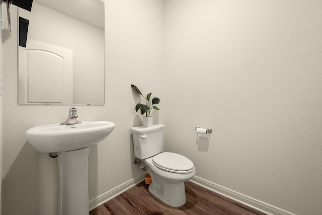 bathroom with hardwood / wood-style flooring and toilet