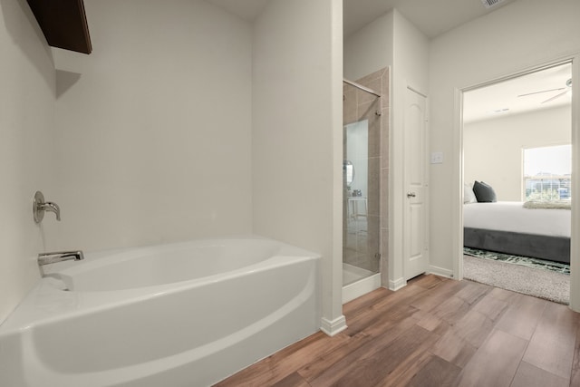 bathroom featuring hardwood / wood-style flooring, separate shower and tub, and ceiling fan