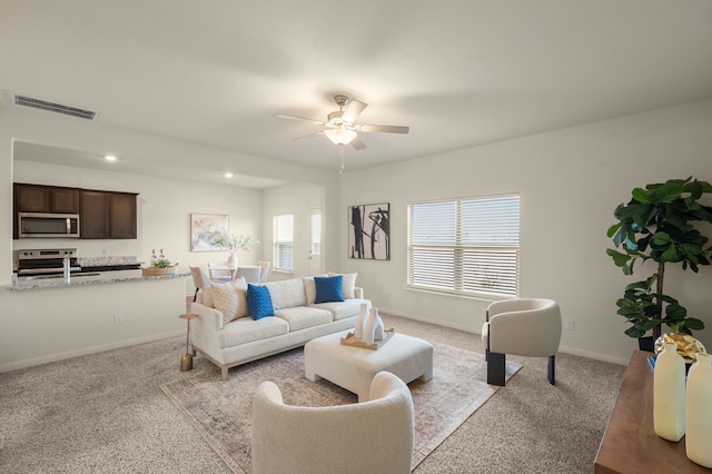 carpeted living room featuring ceiling fan