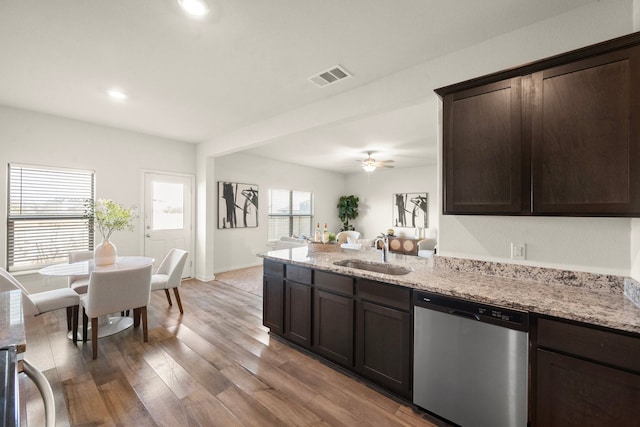 kitchen with sink, stainless steel dishwasher, ceiling fan, light stone countertops, and dark brown cabinetry