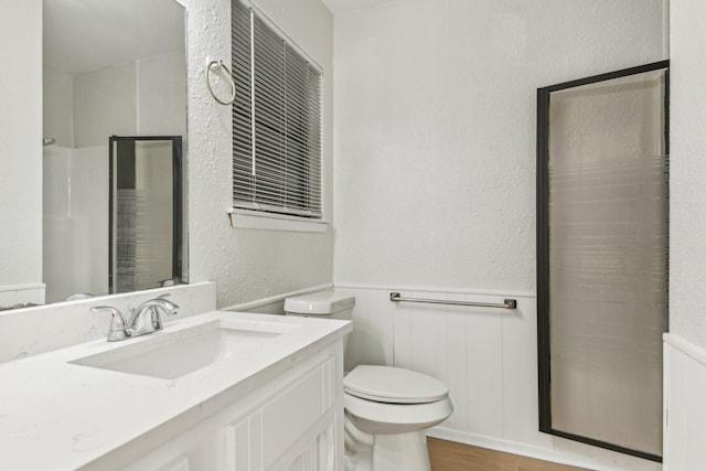 bathroom with toilet, a shower, and vanity