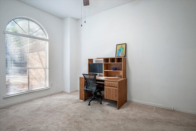 carpeted office space featuring ceiling fan