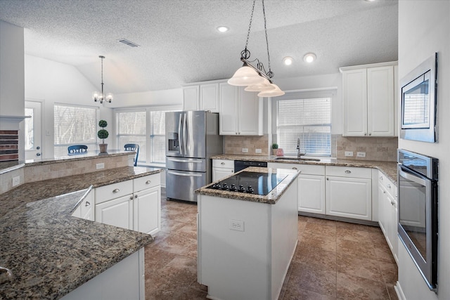 kitchen with a center island, black appliances, white cabinets, sink, and vaulted ceiling