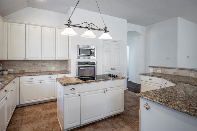 kitchen with decorative backsplash, appliances with stainless steel finishes, a textured ceiling, pendant lighting, and white cabinetry