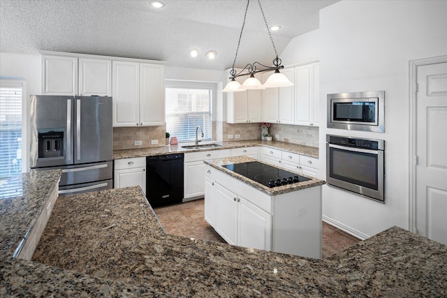 kitchen with lofted ceiling, black appliances, sink, decorative light fixtures, and a kitchen island