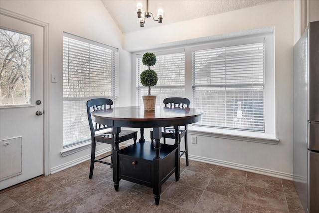 dining room with a notable chandelier, lofted ceiling, and a textured ceiling