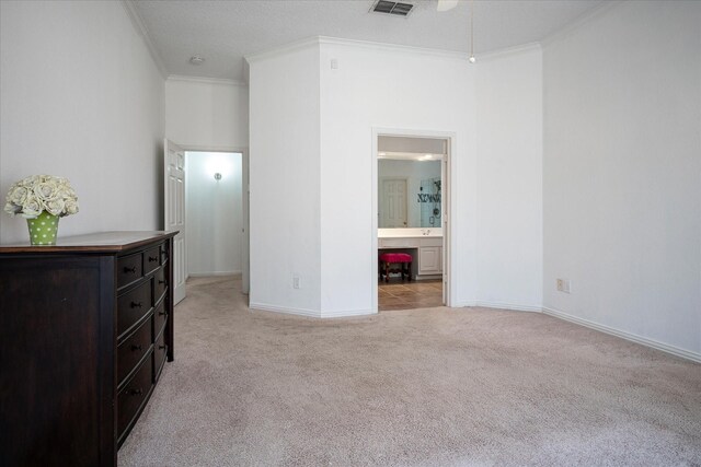 carpeted bedroom featuring ensuite bathroom and crown molding