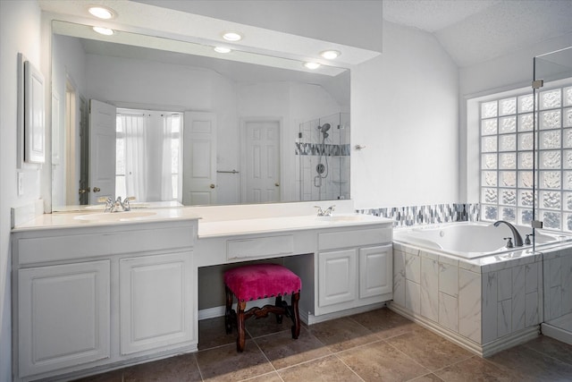 bathroom featuring lofted ceiling, vanity, a textured ceiling, and shower with separate bathtub