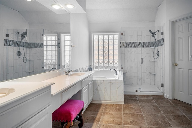 bathroom with a textured ceiling, vanity, vaulted ceiling, and shower with separate bathtub