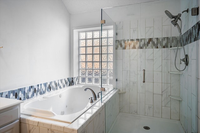 bathroom with a textured ceiling, vanity, and independent shower and bath