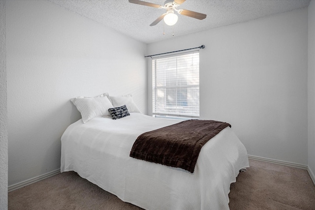 carpeted bedroom featuring ceiling fan and a textured ceiling