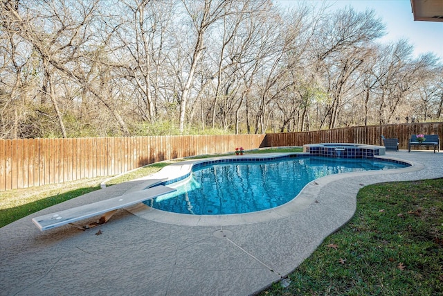 view of pool with an in ground hot tub and a diving board