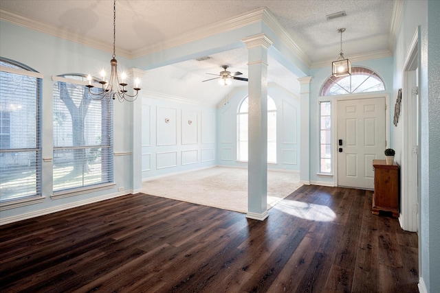 foyer with ceiling fan with notable chandelier, crown molding, dark hardwood / wood-style floors, a textured ceiling, and decorative columns