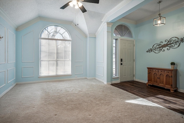 entryway featuring dark carpet, lofted ceiling, and a wealth of natural light