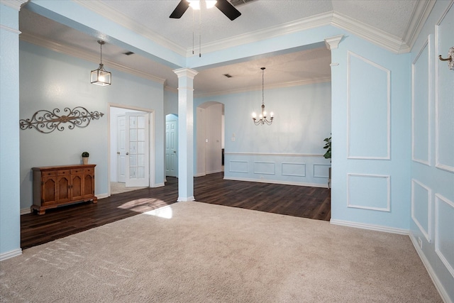 unfurnished room featuring ceiling fan with notable chandelier, dark carpet, a textured ceiling, and ornamental molding