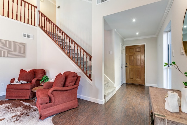 entrance foyer featuring dark hardwood / wood-style flooring, a high ceiling, and ornamental molding