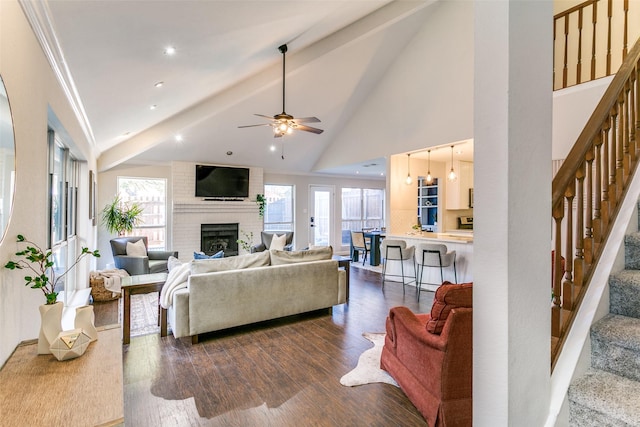 living room with a healthy amount of sunlight, ceiling fan, dark wood-type flooring, and a brick fireplace