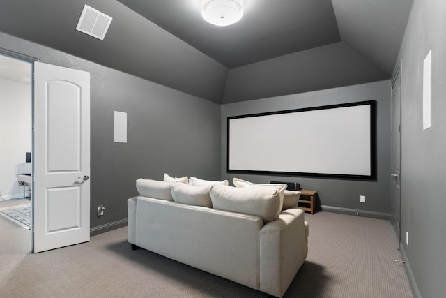 carpeted home theater with vaulted ceiling