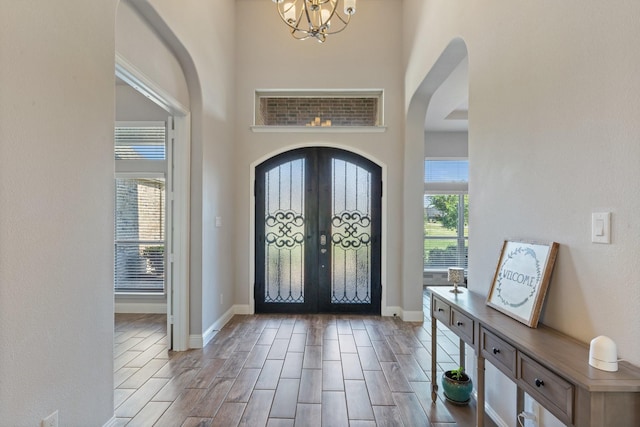 foyer featuring french doors and an inviting chandelier