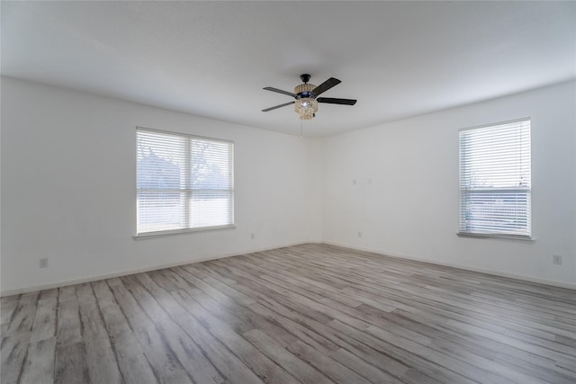 spare room with baseboards, a ceiling fan, and wood finished floors