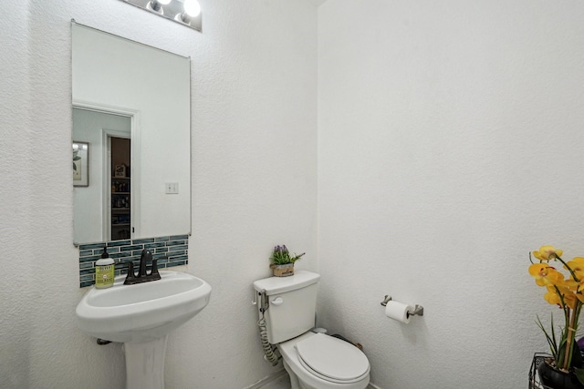 bathroom with tasteful backsplash and toilet