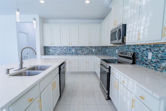 kitchen featuring white cabinets, marble finish floor, stainless steel appliances, pendant lighting, and a sink