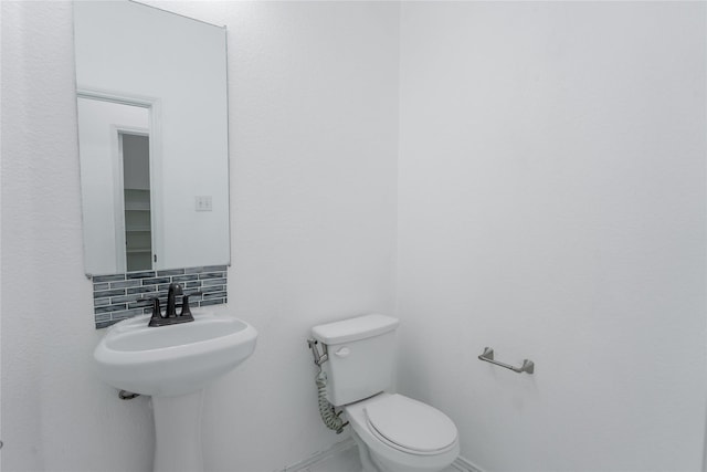 half bath with tasteful backsplash and toilet