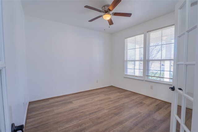 unfurnished room featuring a ceiling fan, french doors, baseboards, and wood finished floors