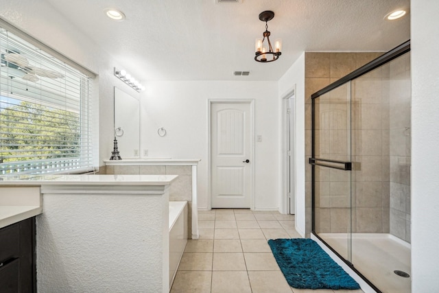 bathroom with tile patterned floors, vanity, plus walk in shower, and an inviting chandelier