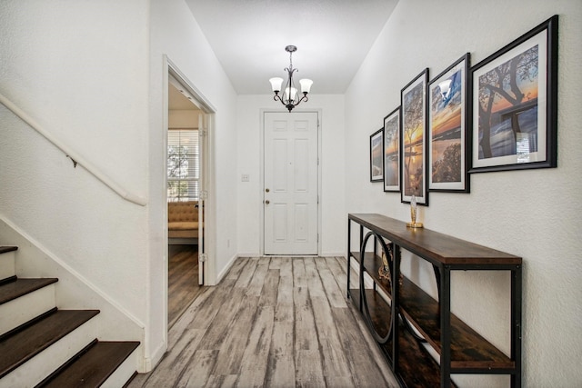 foyer entrance featuring hardwood / wood-style flooring and an inviting chandelier