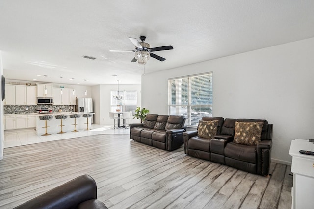 living room featuring light hardwood / wood-style flooring and ceiling fan