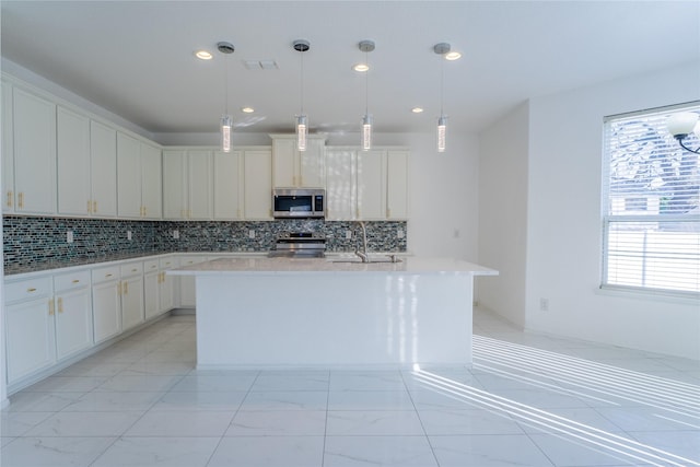 kitchen with marble finish floor, stainless steel appliances, light countertops, and a wealth of natural light